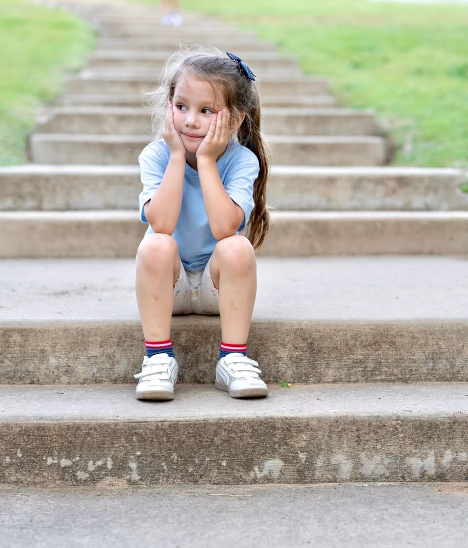 Little girl sitting on outdoor steps